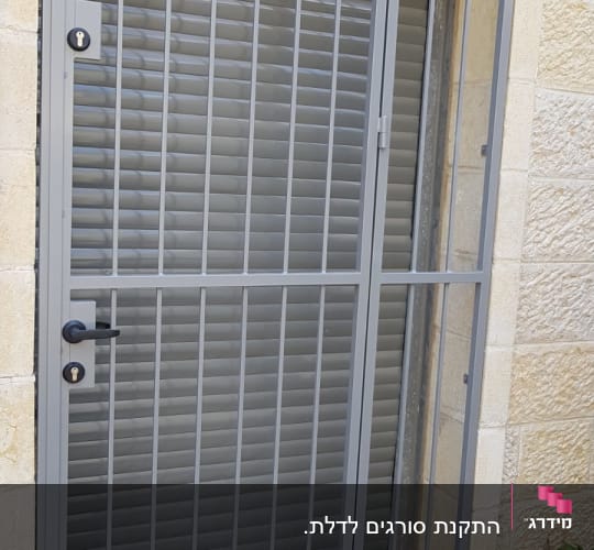 דלת מתכת עם סורגים ומנעול